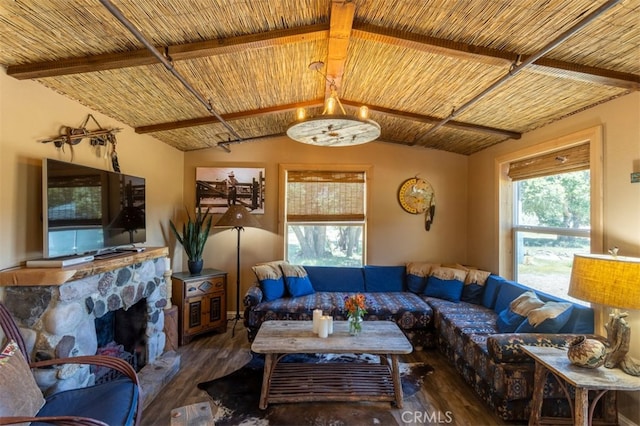 living room with vaulted ceiling with beams, wood ceiling, wood-type flooring, and a stone fireplace