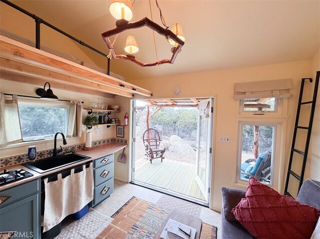 kitchen with black gas stovetop, sink, plenty of natural light, and hanging light fixtures