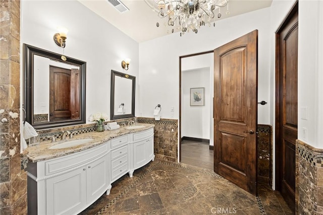 bathroom with vanity, tile walls, and a chandelier