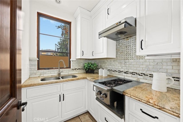 kitchen featuring ventilation hood, white cabinetry, sink, and tasteful backsplash