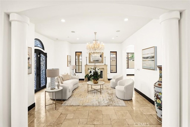 sitting room featuring decorative columns and a notable chandelier