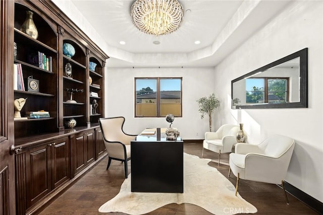 office space featuring plenty of natural light, an inviting chandelier, dark hardwood / wood-style flooring, and a tray ceiling