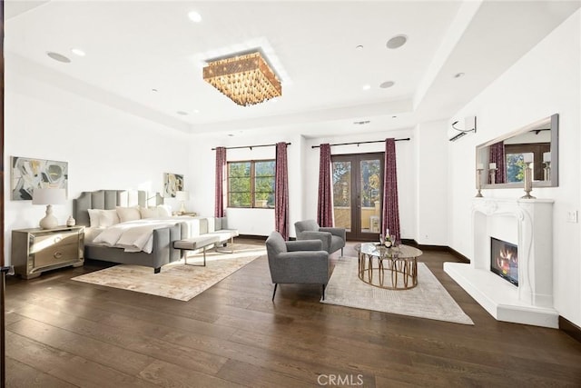 bedroom featuring dark hardwood / wood-style floors, french doors, and a wall mounted AC