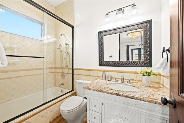 full bathroom featuring vanity, toilet, and bath / shower combo with glass door