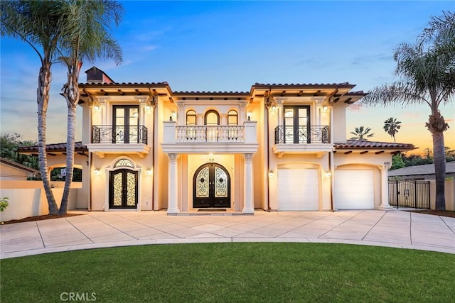 mediterranean / spanish home featuring french doors, a balcony, and a garage