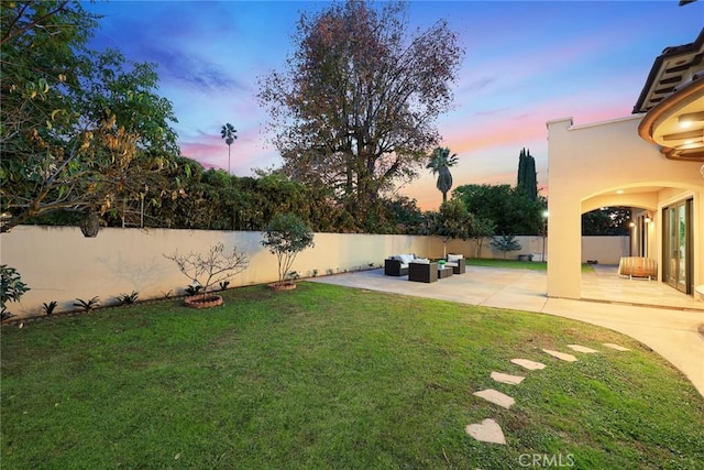 yard at dusk with outdoor lounge area and a patio area