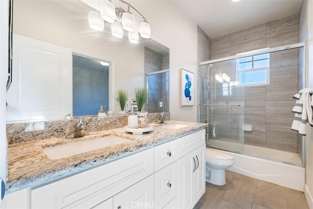 full bathroom featuring shower / bath combination with glass door, tile patterned floors, vanity, and toilet