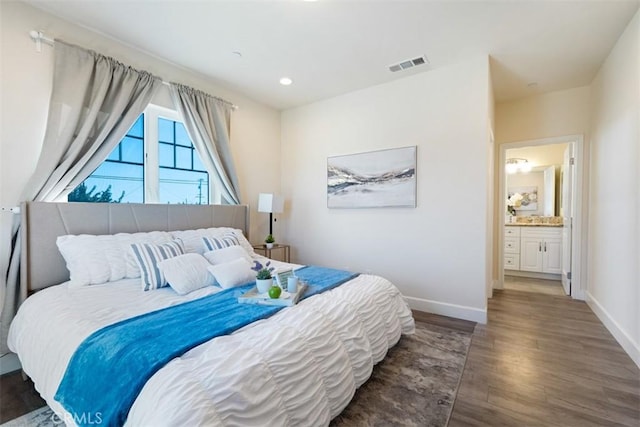 bedroom featuring dark hardwood / wood-style flooring and ensuite bathroom