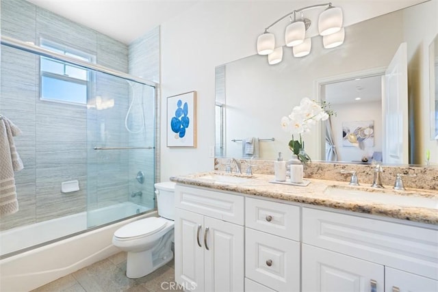 full bathroom featuring toilet, tile patterned flooring, vanity, and combined bath / shower with glass door