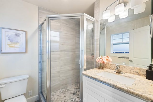 bathroom featuring vanity, an enclosed shower, and toilet