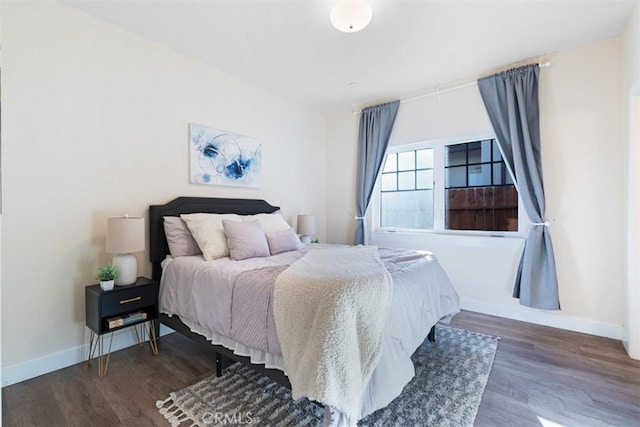 bedroom with dark hardwood / wood-style flooring