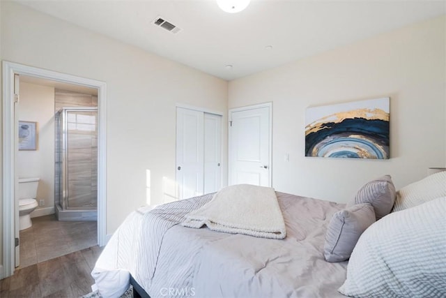 bedroom featuring wood-type flooring, ensuite bath, and a closet