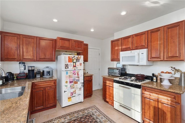 kitchen featuring light stone counters, white appliances, sink, and light tile patterned floors