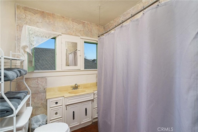 bathroom featuring vanity, tile walls, and toilet