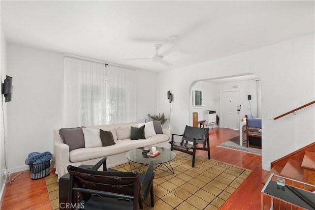 living room with heating unit, hardwood / wood-style flooring, and ceiling fan