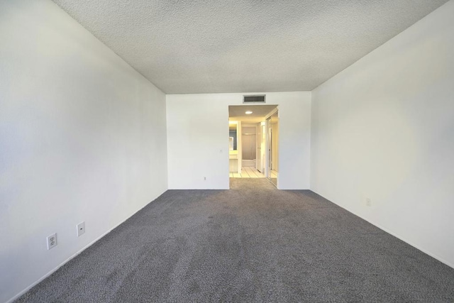 unfurnished room with a textured ceiling and carpet floors