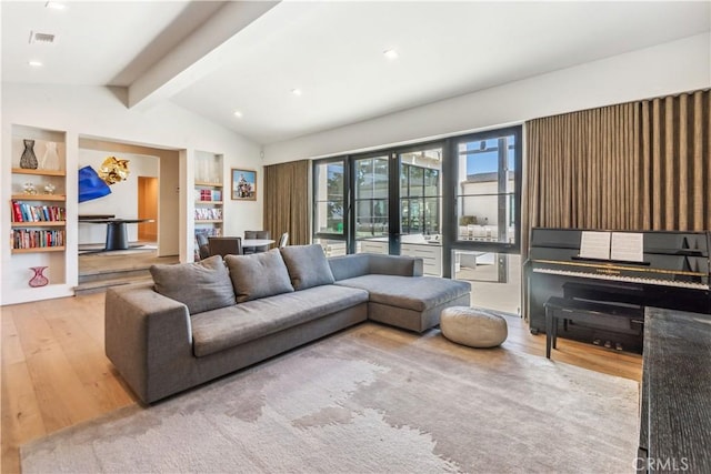 living room featuring french doors, lofted ceiling with beams, and light wood-type flooring