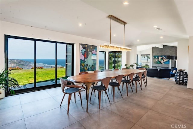 dining area with light tile patterned floors and vaulted ceiling