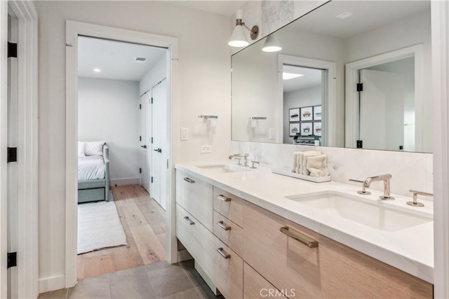 bathroom featuring decorative backsplash, vanity, and hardwood / wood-style flooring