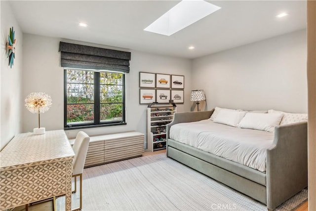 bedroom featuring a skylight and hardwood / wood-style flooring