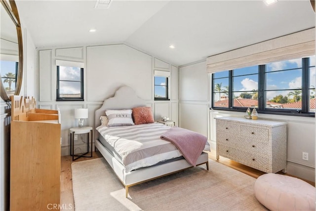 bedroom with lofted ceiling and light hardwood / wood-style flooring