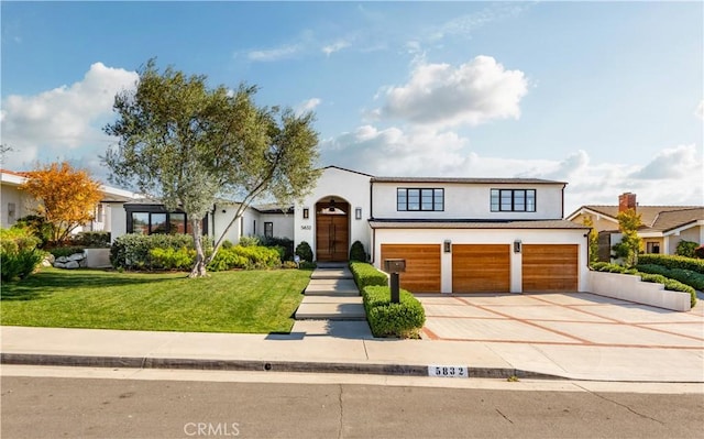 view of front of house featuring a garage and a front lawn