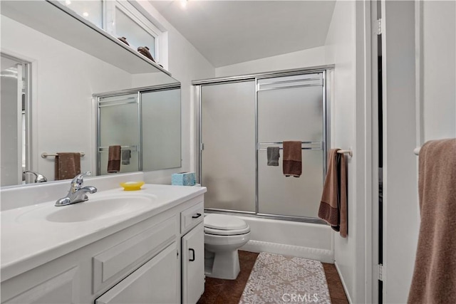 full bathroom featuring toilet, enclosed tub / shower combo, tile patterned floors, and vanity