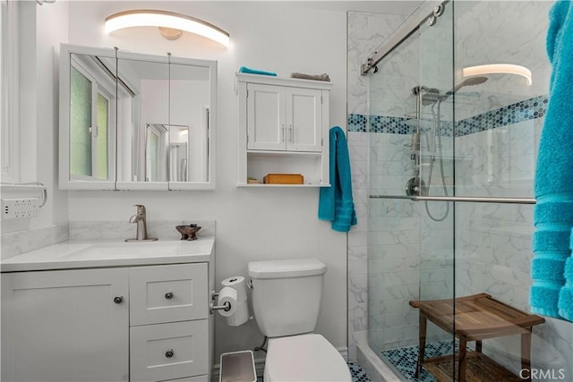 bathroom with an enclosed shower, vanity, and toilet