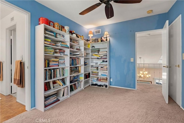 interior space with light carpet and ceiling fan with notable chandelier