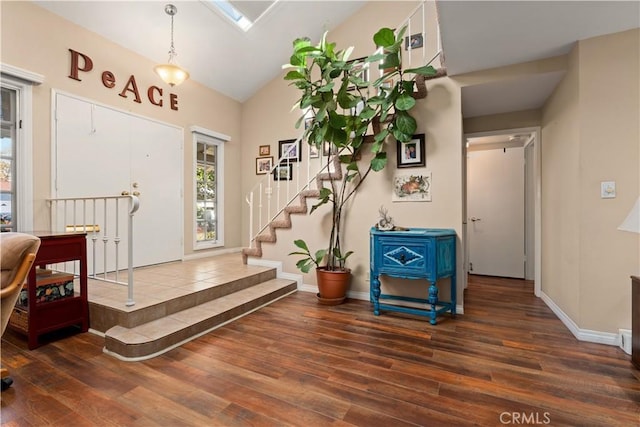 foyer with dark hardwood / wood-style floors and lofted ceiling with skylight