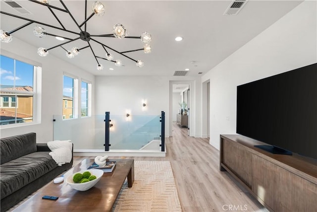 living room with light wood-type flooring and a notable chandelier