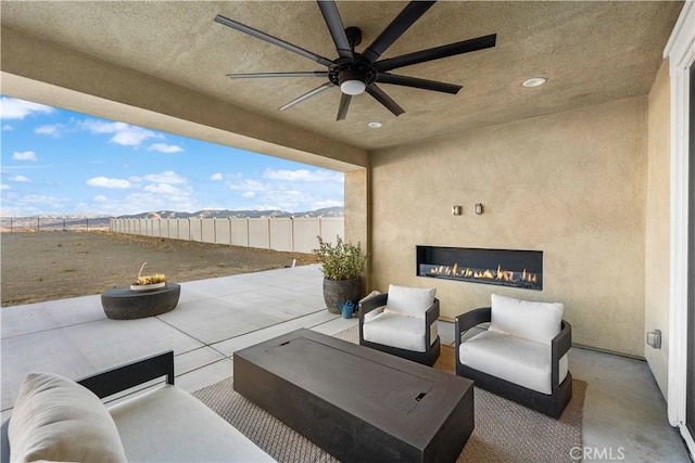 view of patio / terrace featuring ceiling fan, a mountain view, and an outdoor living space