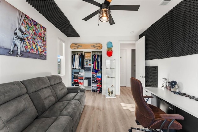 office space featuring ceiling fan, light hardwood / wood-style floors, and built in desk