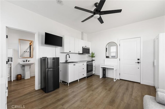 kitchen featuring white cabinetry, ceiling fan, sink, dark wood-type flooring, and black refrigerator