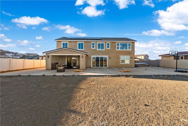 rear view of property featuring solar panels and a patio