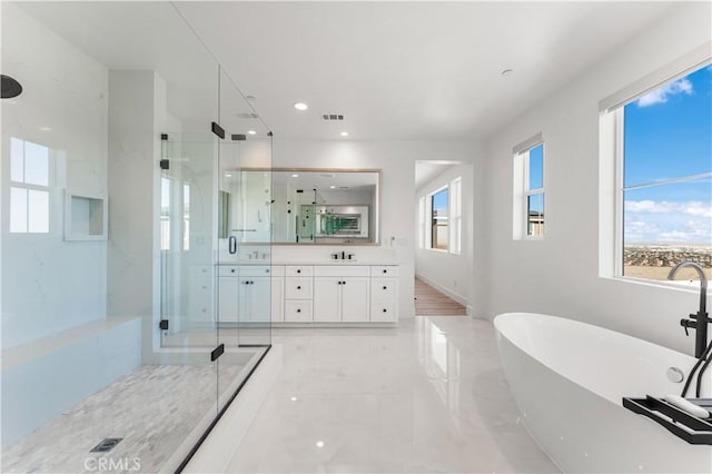 bathroom with vanity and shower with separate bathtub