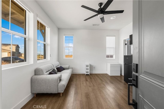 sitting room with ceiling fan and dark hardwood / wood-style flooring