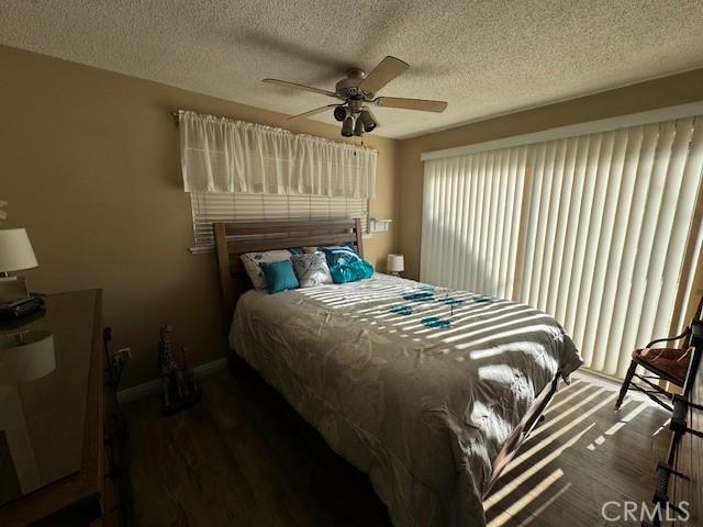 bedroom featuring a textured ceiling, dark hardwood / wood-style flooring, and ceiling fan