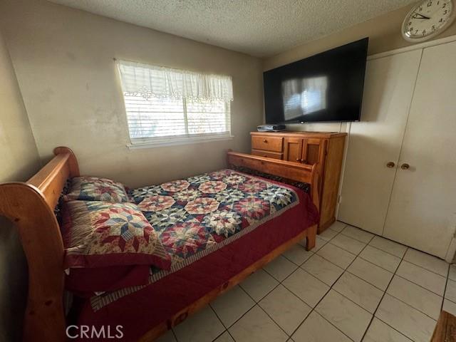 bedroom with light tile patterned floors and a textured ceiling