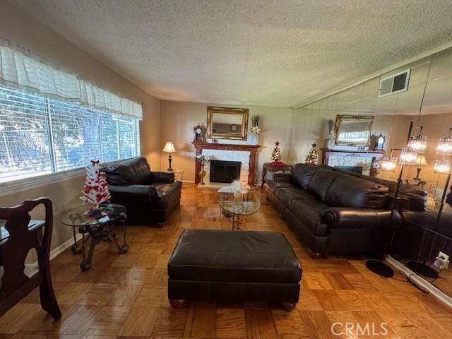 living room with lofted ceiling, parquet flooring, and a textured ceiling