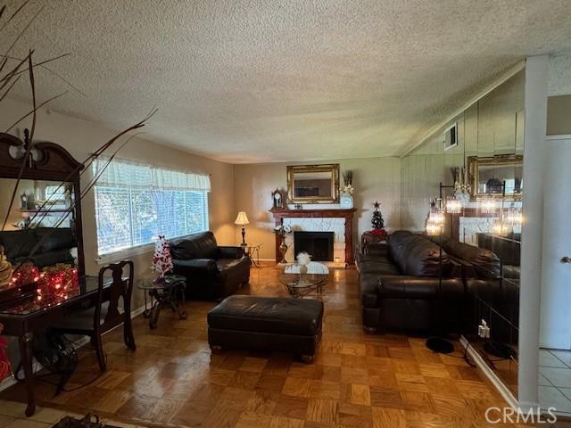 living room featuring lofted ceiling, parquet flooring, and a textured ceiling