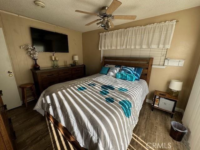 bedroom featuring ceiling fan, dark hardwood / wood-style flooring, and a textured ceiling