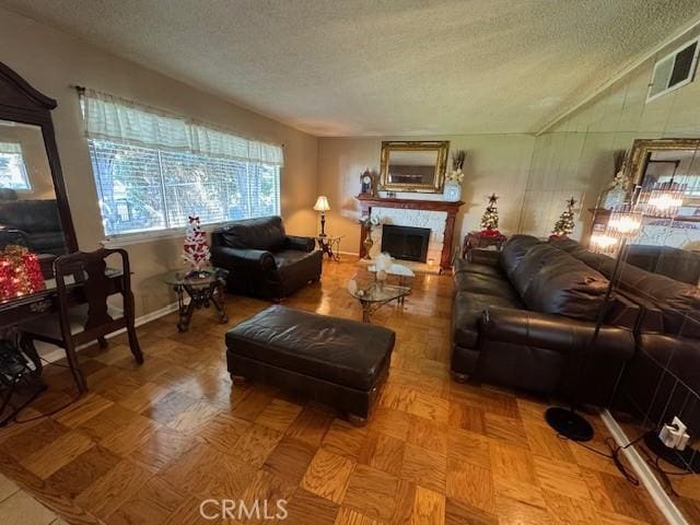 living room featuring lofted ceiling and a textured ceiling