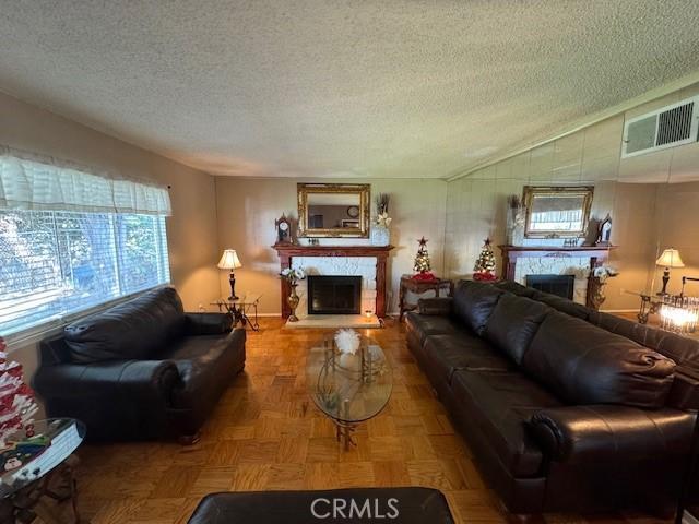 living room with lofted ceiling, parquet floors, and a textured ceiling