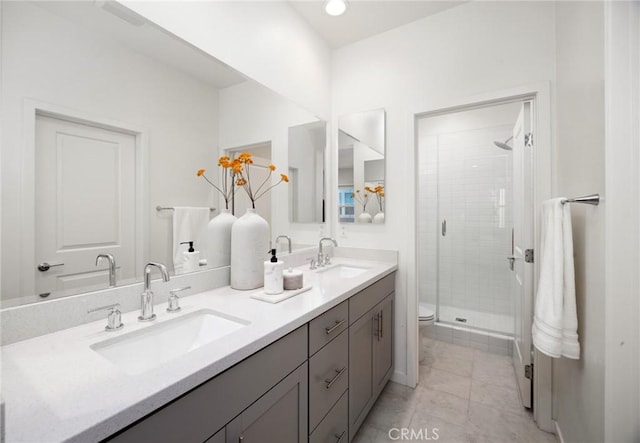 bathroom with an enclosed shower, vanity, toilet, and tile patterned flooring