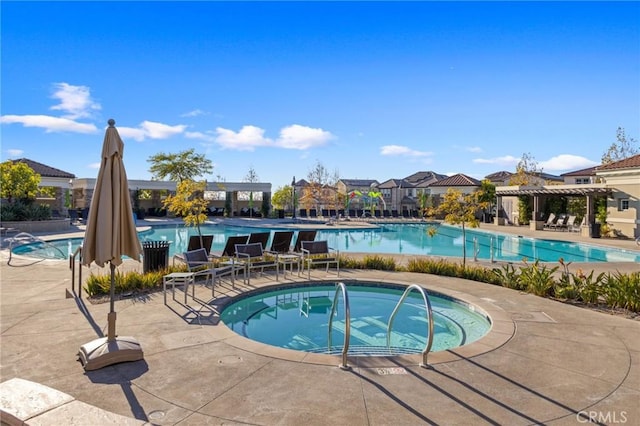 view of swimming pool with a jacuzzi and a patio