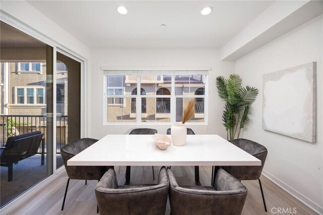 dining room with plenty of natural light and light hardwood / wood-style flooring