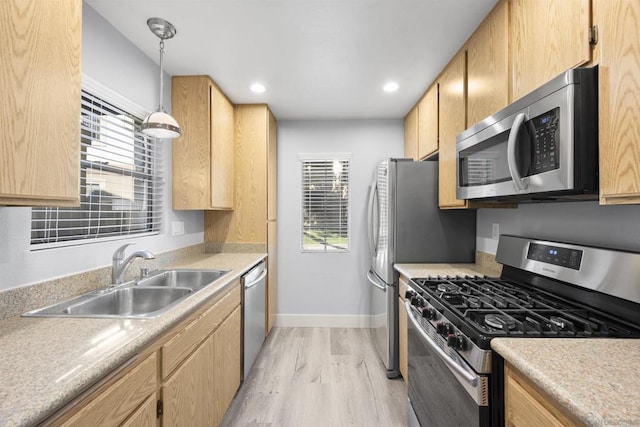 kitchen featuring sink, a healthy amount of sunlight, light wood-type flooring, and appliances with stainless steel finishes