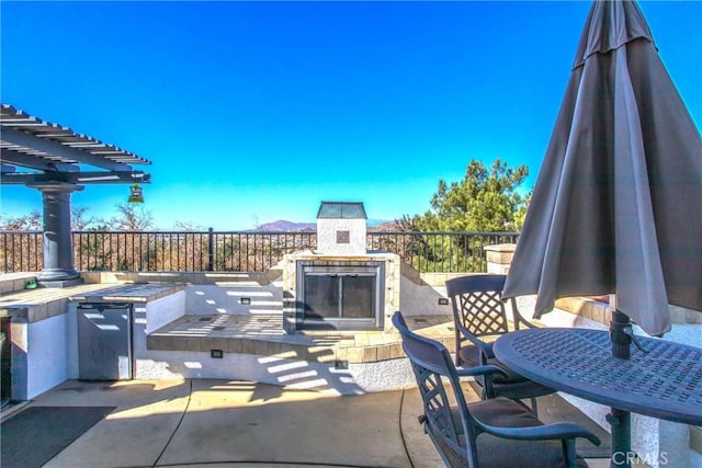 view of patio with an outdoor fireplace