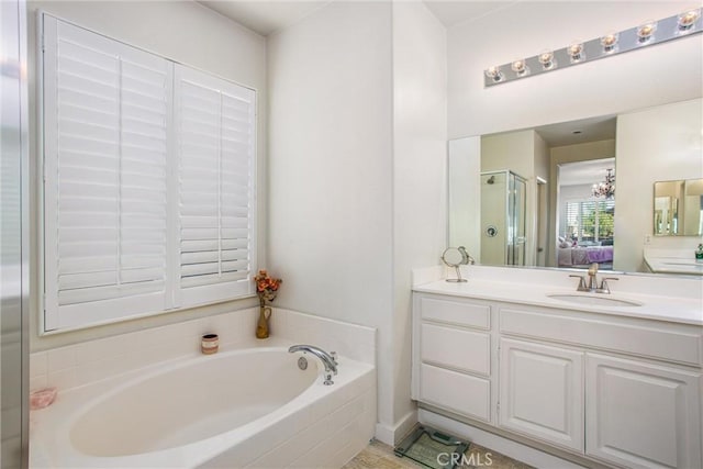 bathroom featuring shower with separate bathtub, vanity, and an inviting chandelier